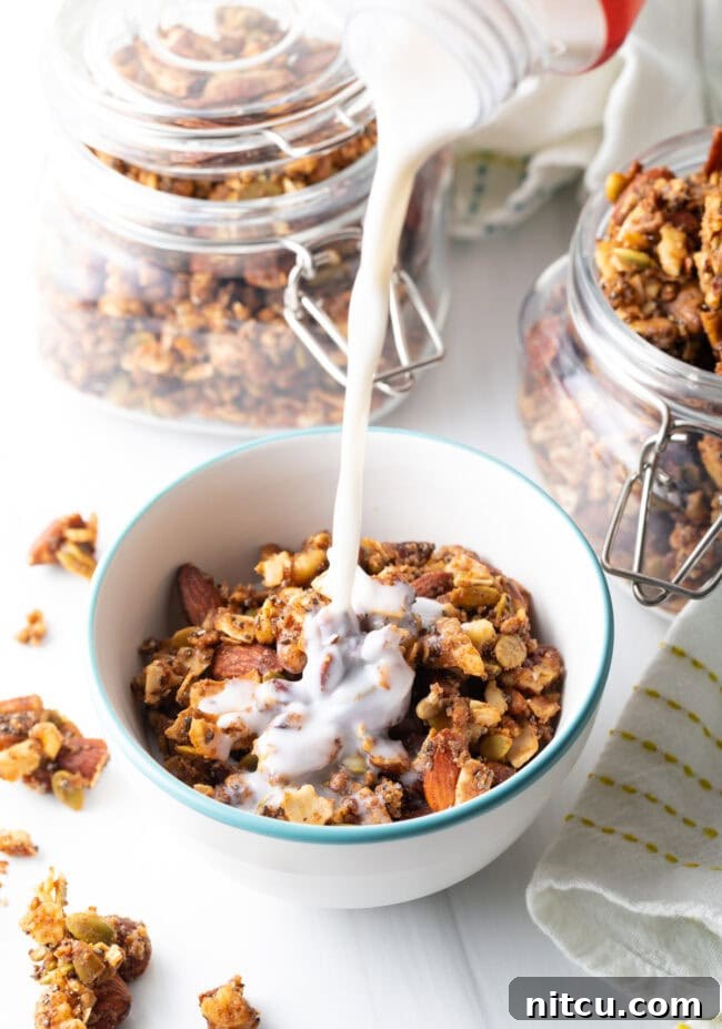 Pouring milk from a jug into a bowl of keto nut granola, ready for breakfast.