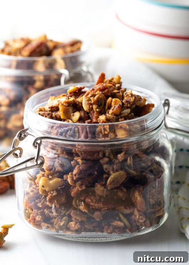 Close-up side view of a glass jar filled with golden, crunchy keto granola.