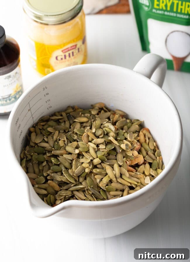 Various seeds and coconut chips being added to the nut mixture.