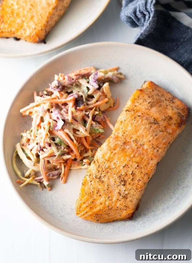 Top view salmon on a plate with coleslaw. Perfectly cooked air fryer salmon.