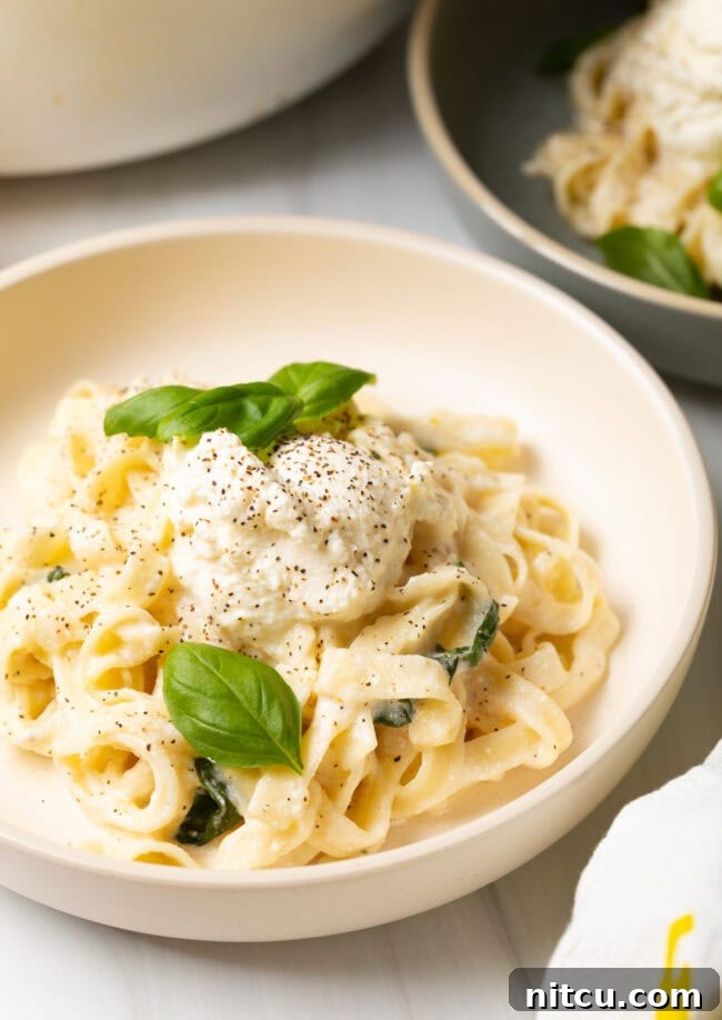 Bowl of lemon ricotta pasta topped with fresh basil, ready to be enjoyed.