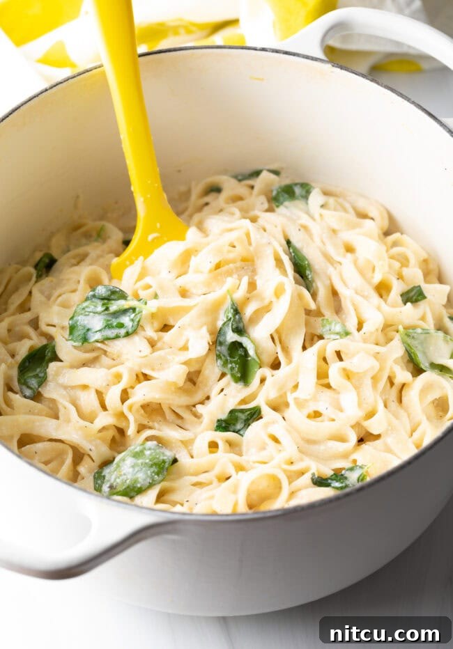 Noodles in a pot, with creamy lemon cheese sauce and fresh basil ready to serve.