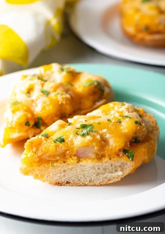 Close-up view of a Cajun Shrimp Toast recipe, showing toasted baguette topped with creamy, spicy shrimp, melted cheese, and fresh parsley.