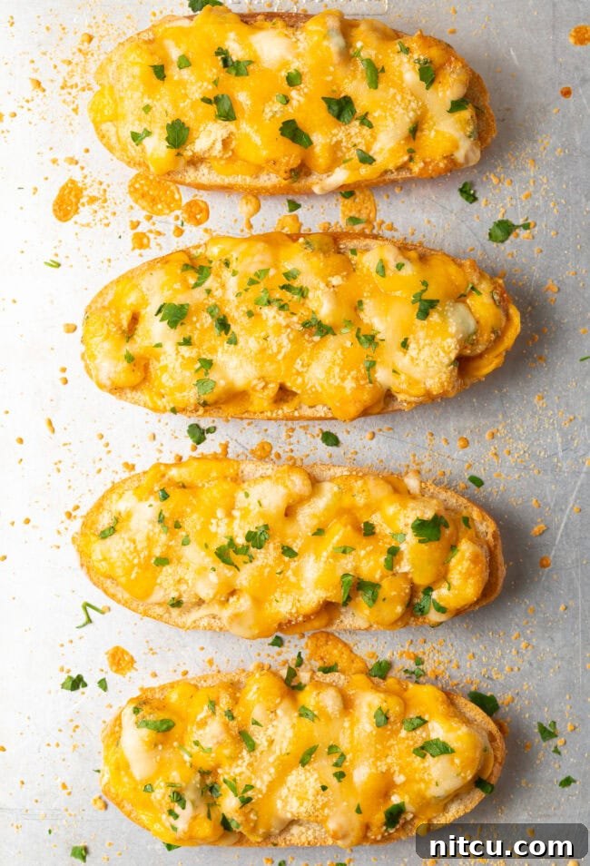Top-down view of four perfectly baked, cheesy Cajun shrimp toast pieces, garnished with fresh herbs, ready for serving.