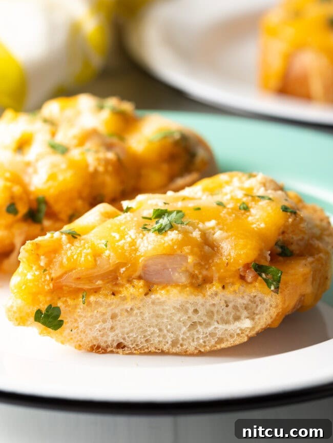 A close-up view of a baked shrimp toast with perfectly melted cheese and golden-brown bread, garnished with fresh herbs.