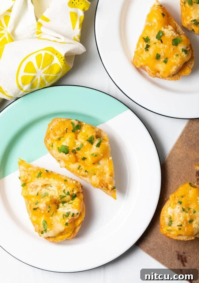 Top-down view of two pieces of perfectly baked cheesy Cajun shrimp bread on a white plate, ready to be served.