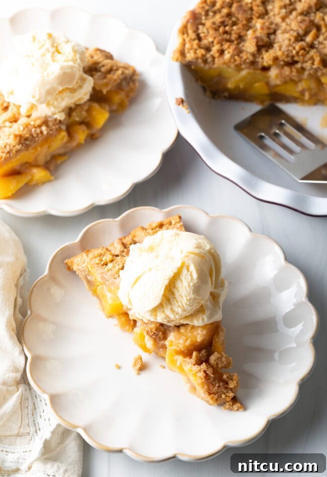 Final top-down shot of a golden-brown peach crumble pie, ready to be served, perfect with fresh or frozen peaches.