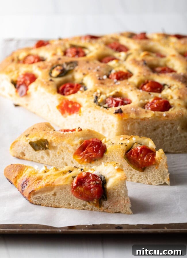Tomato bread sliced from a large loaf of focaccia.