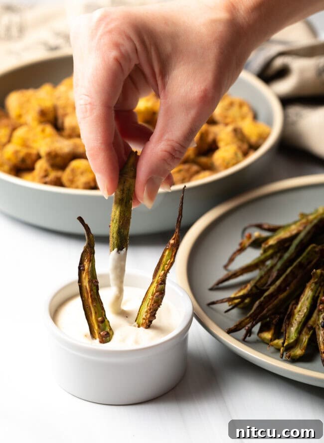 Hand dipping okra fries into aioli.