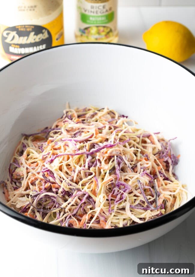 A top-down shot of a bowl brimming with creamy, fresh coleslaw, garnished and ready to serve.