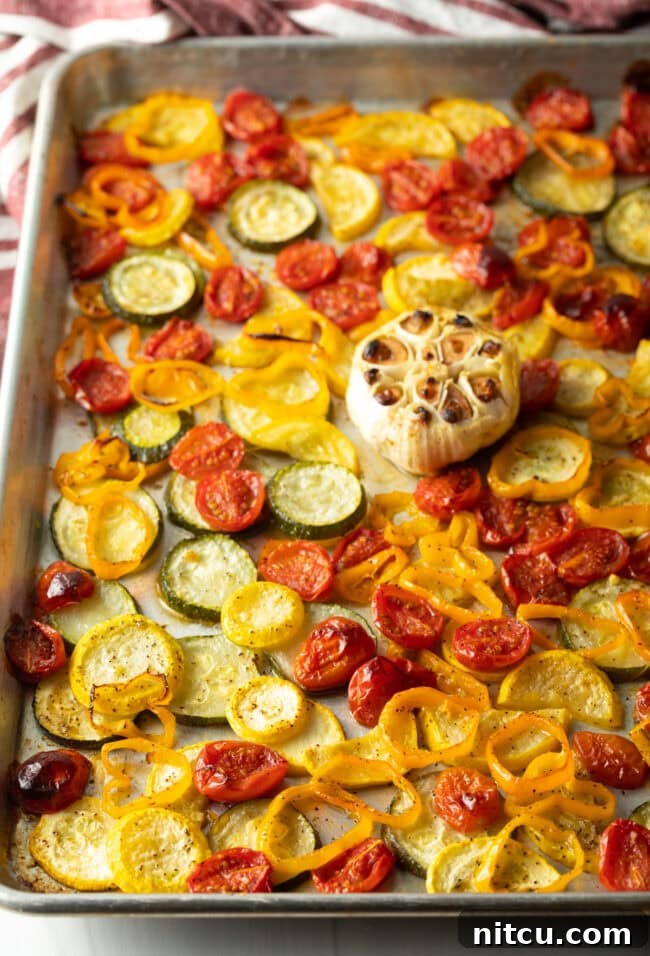 Roasted summer vegetables on a sheet pan after the first roasting phase.
