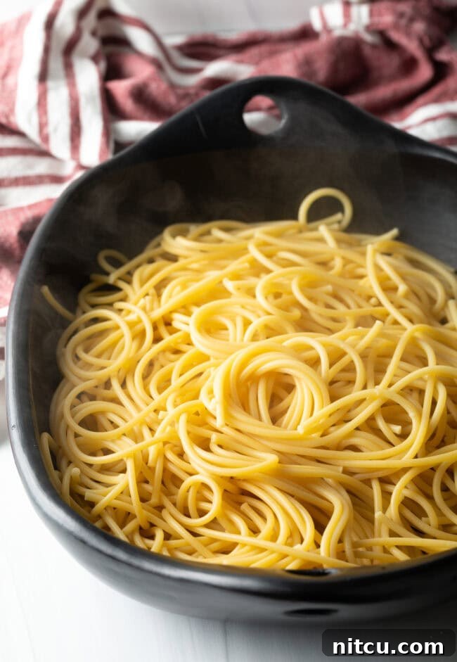 Bowl of cooked spaghetti, ready to be combined with the roasted vegetables.