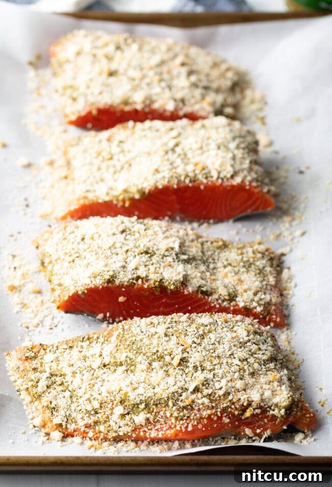 4 raw pieces of pesto salmon coated with Panko breadcrumbs.