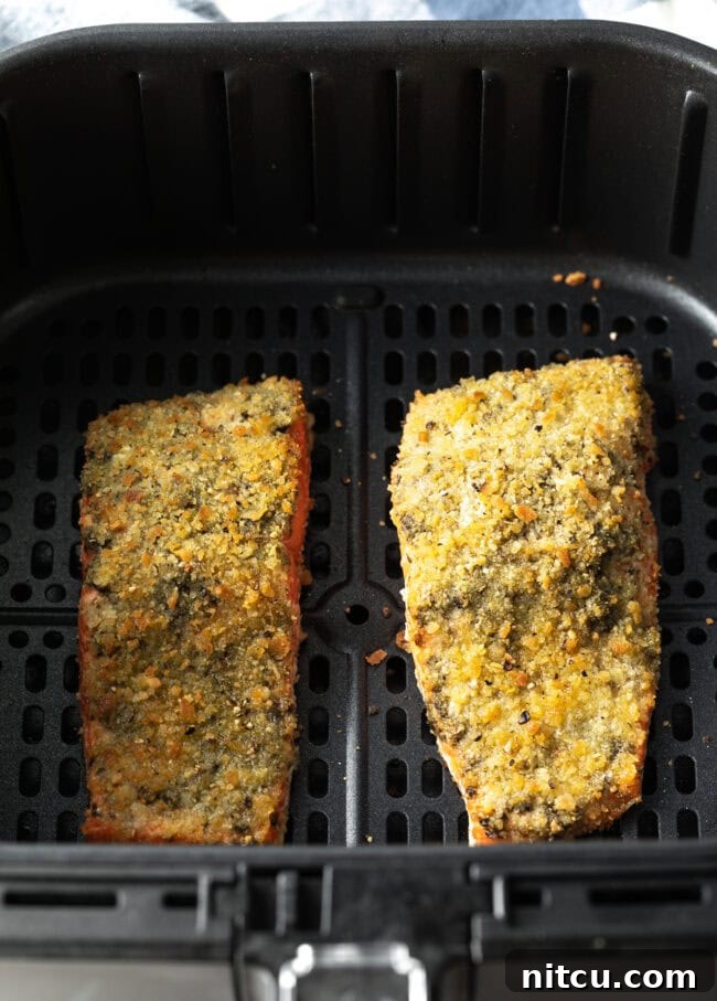 Two pieces of pesto salmon in the air fryer.