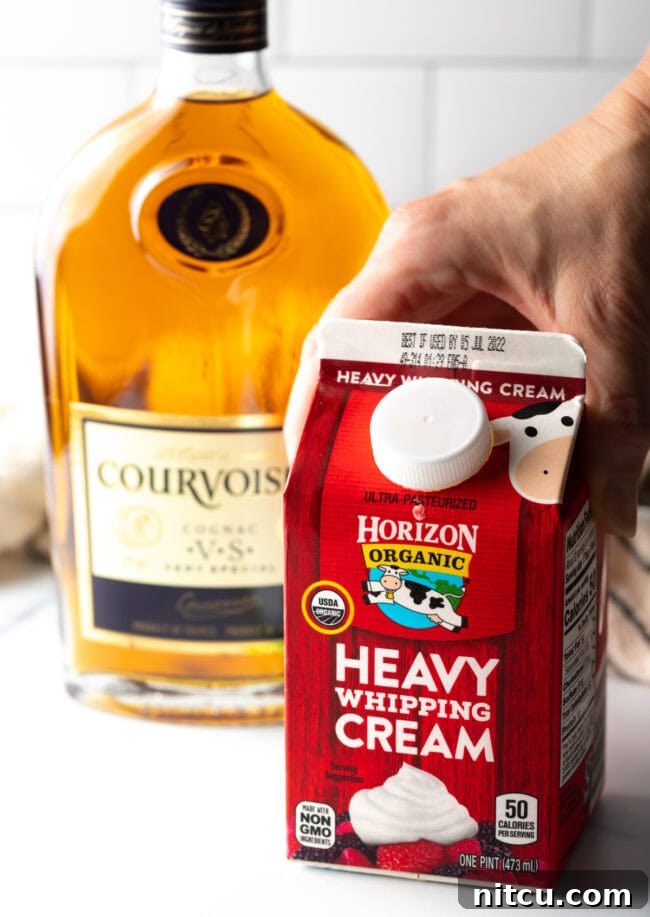 Container of heavy whipping cream and bottle of cognac.