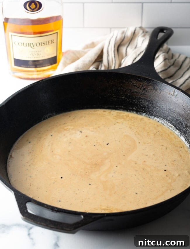 Cream sauce cooking in a cast iron skillet.