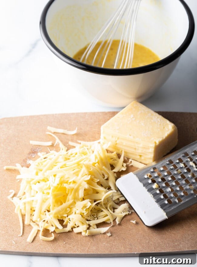 Shredded cheddar cheese on a cutting board.