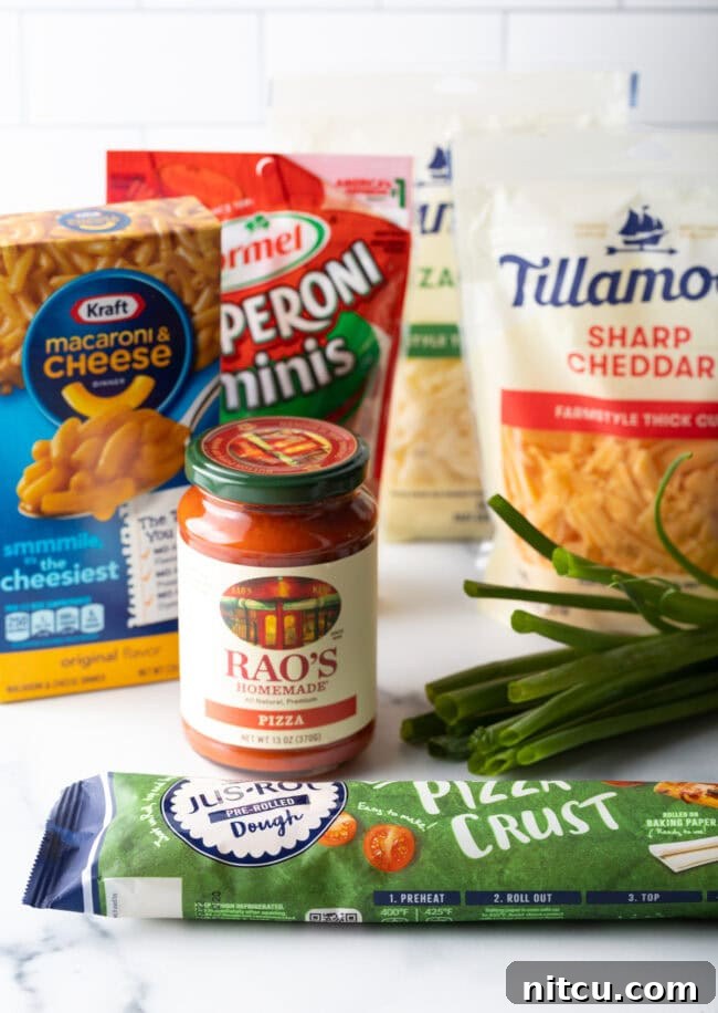 Closeup of ingredients for mac and cheese pizza. These include Kraft macaroni & cheese, pizza sauce, bagged shredded cheese, green onions and packaged pizza crust.