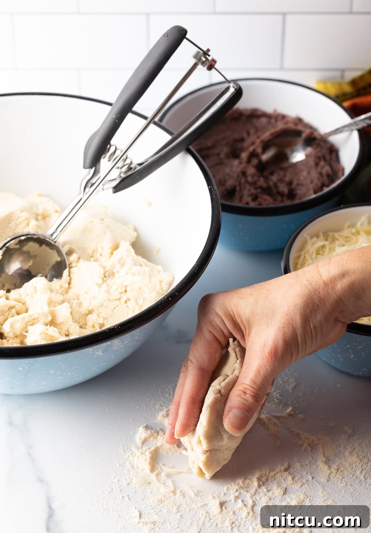 Hand gently folding the edges of the dough over the filling.