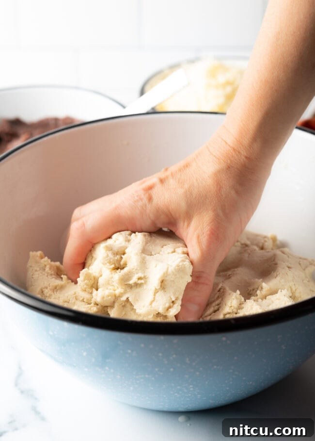 Hands shaping masa harina and water into a soft, smooth dough.