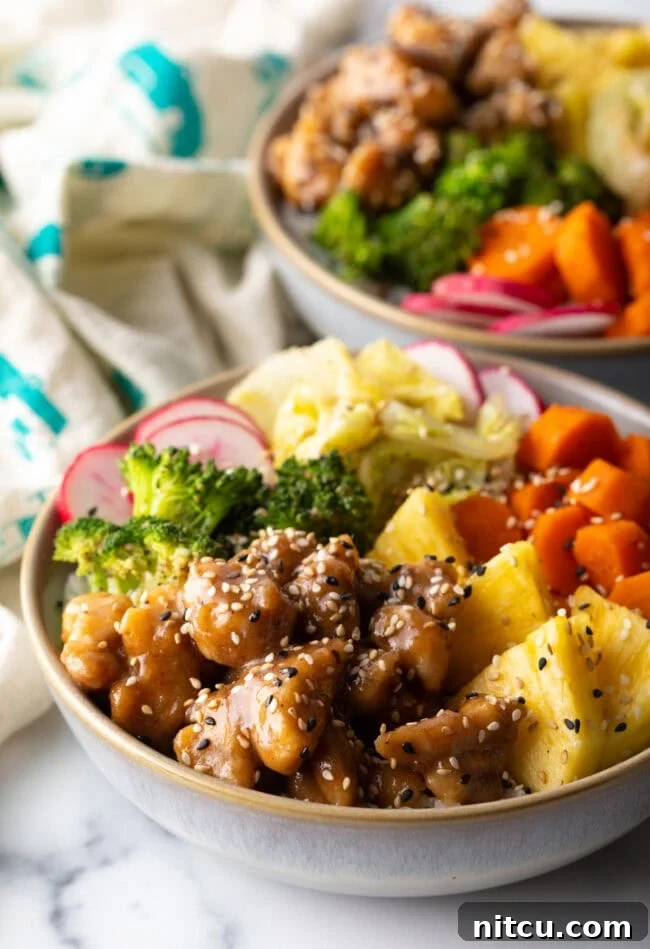 Chicken teriyaki bowl with pineapple, carrots, broccoli, cabbage, and radishes.