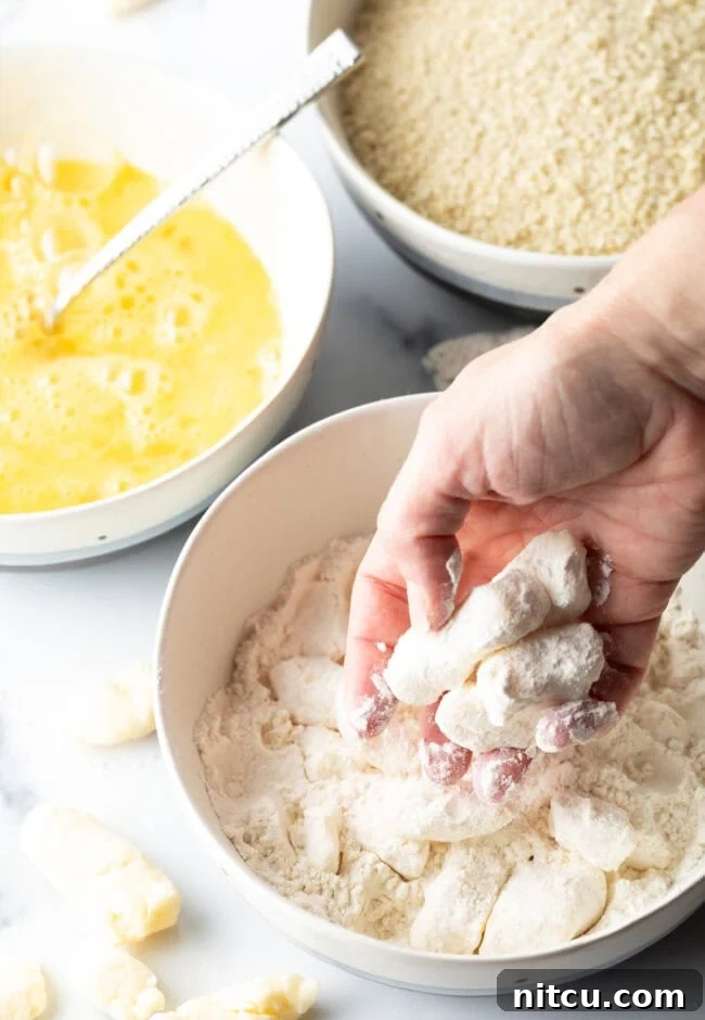 Dredging cheese curds in egg and flour.