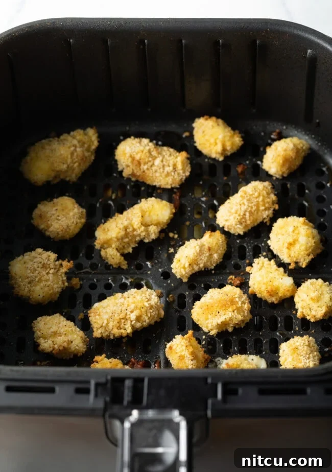 Two dozen air fried cheese curds in the air fryer.