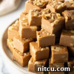 Small, perfectly formed maple walnut fudge squares, ready to be served or enjoyed, showing a tempting close-up of the texture.