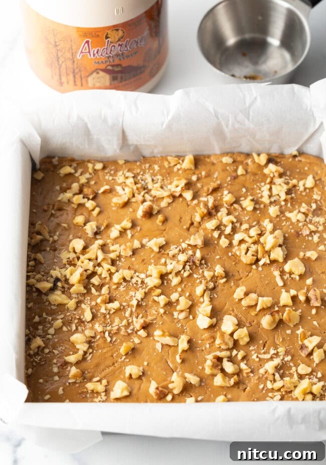 Additional chopped walnuts artfully sprinkled over the top of the set maple fudge, adding visual appeal and extra crunch.