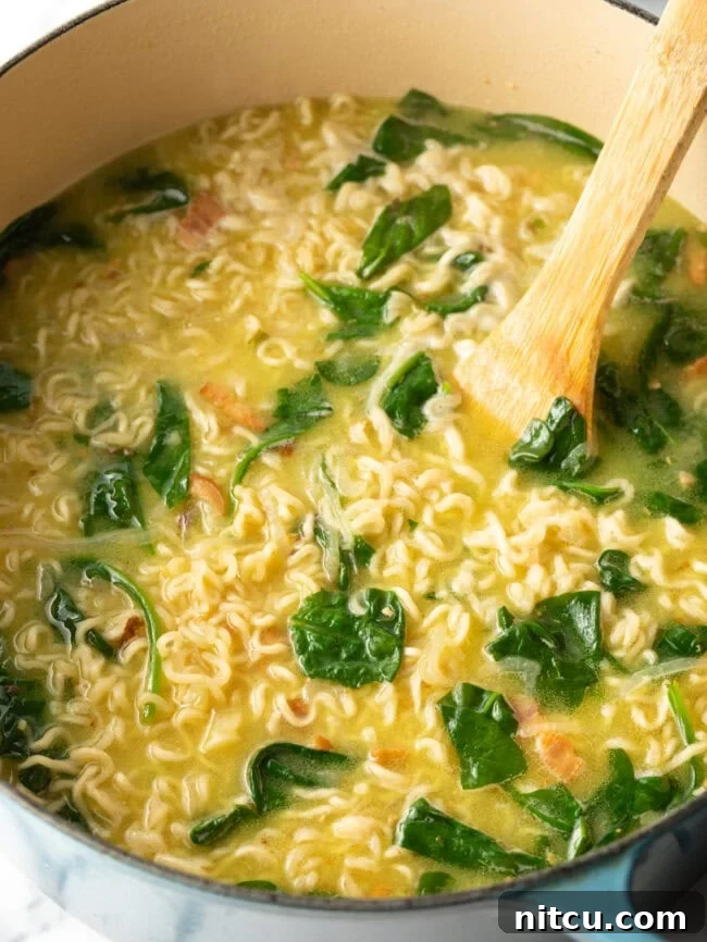 Wood spoon stirring katsu ramen in a pot.