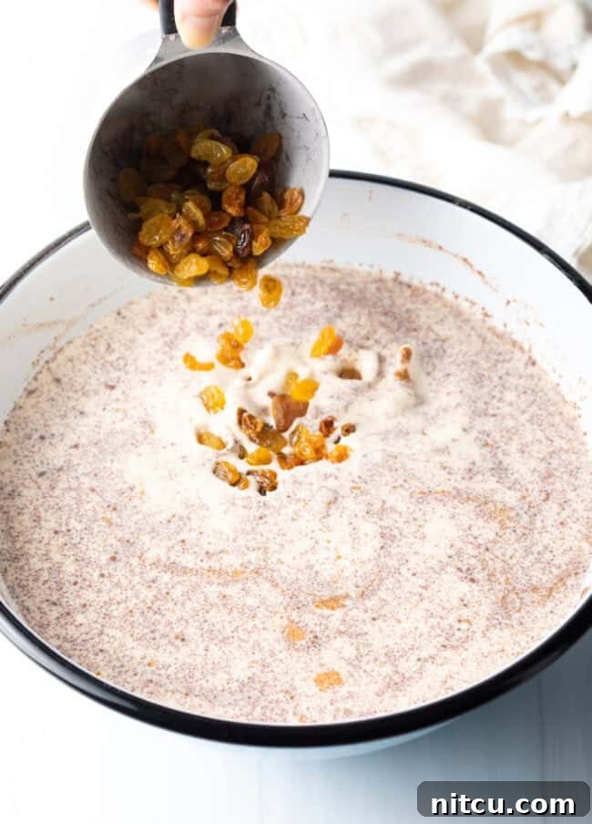 Sprinkling golden raisins into the rich rice and cream mixture, adding sweet bursts of fruit.