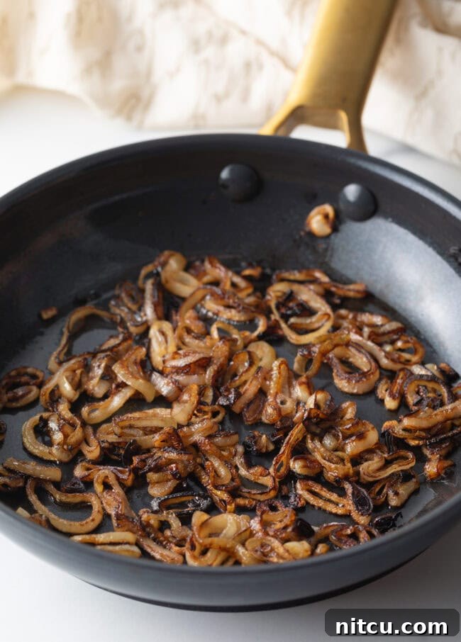 Sauteeing sliced shallots in a skillet until browned.