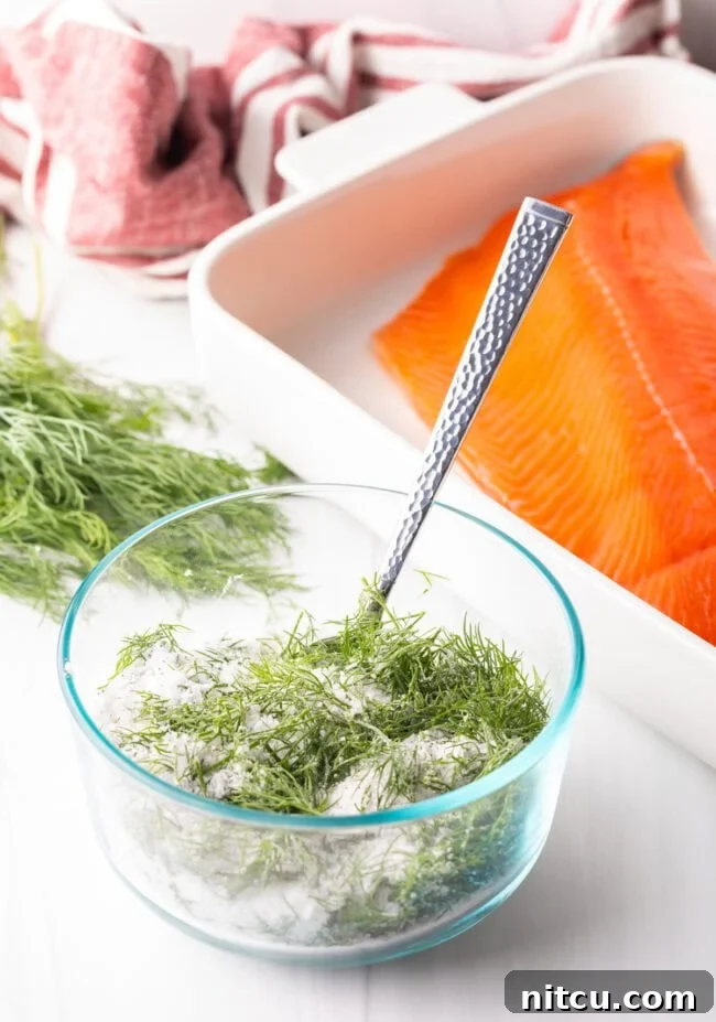 Dill, salt and sugar combined in a small glass bowl, showcasing the curing mixture.