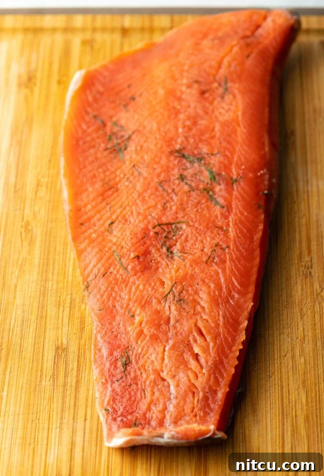 Unwrapped and rinsed salmon fillet on a cutting board, perfectly cured and ready for slicing.