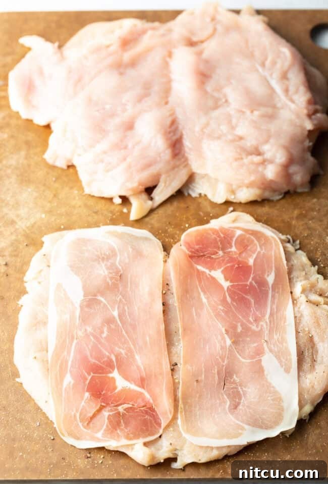 Butterflied chicken with slices of prosciutto on each half, ready for filling.