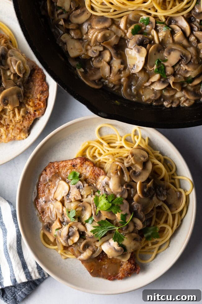 Top down view two plates of veal scallopini.