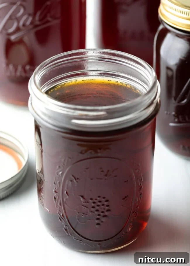 Close up view of beef consomme in a glass jar.