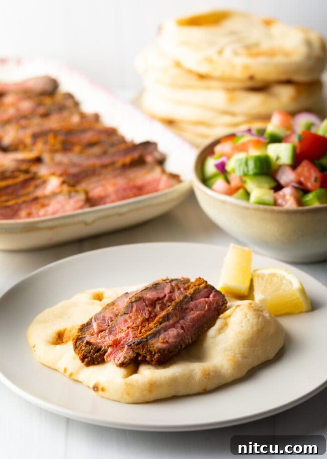 Flatbread on plate with slices of beef.