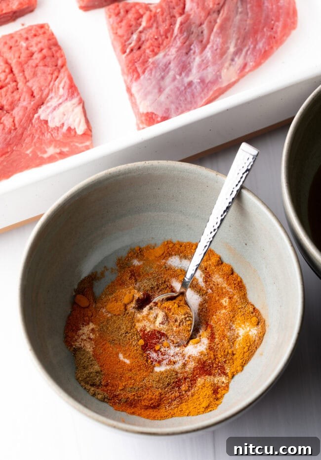 Bowl with blend of spices and metal spoon.