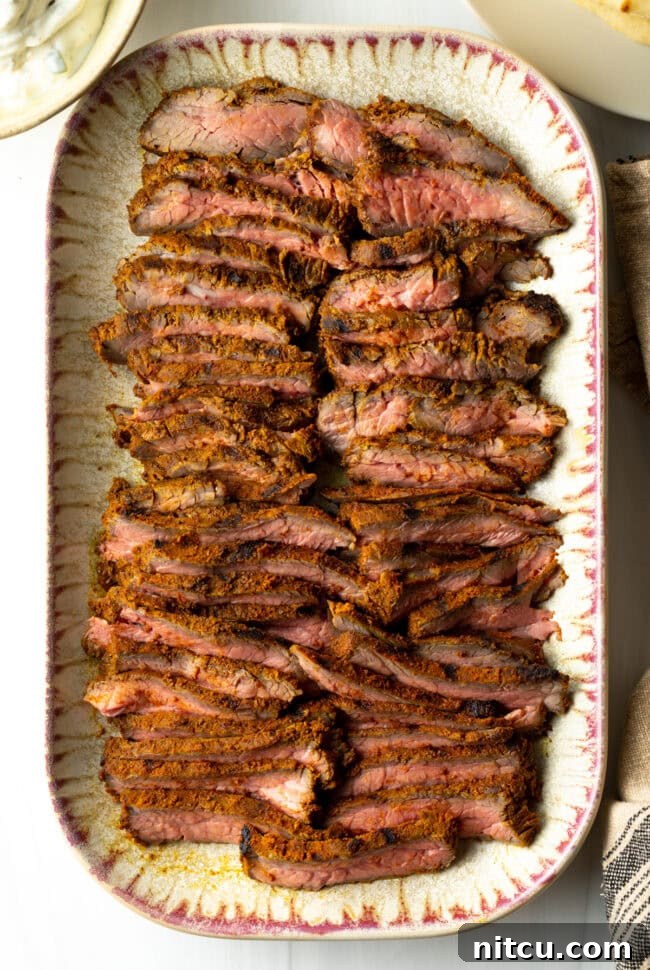 Top down slices of beef on a serving platter for shawarma or gyro.