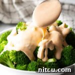 A small image of broccoli with cheese sauce.