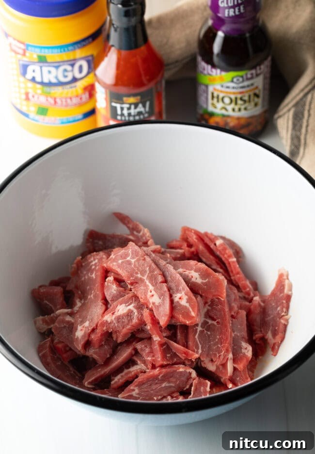 Thinly sliced beef in a white mixing bowl.