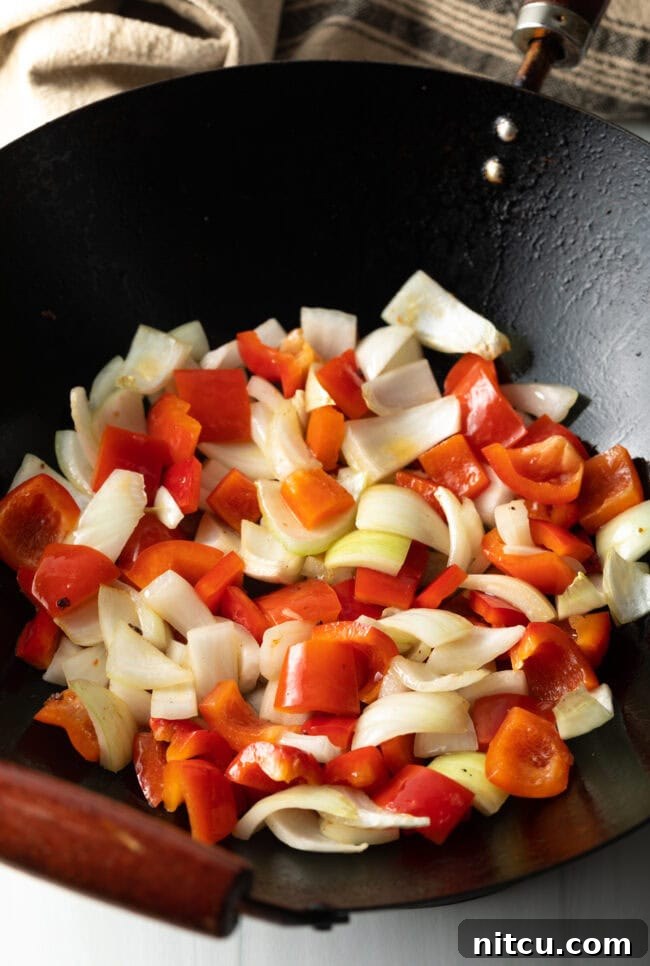 Raw pepper and onions in a skillet