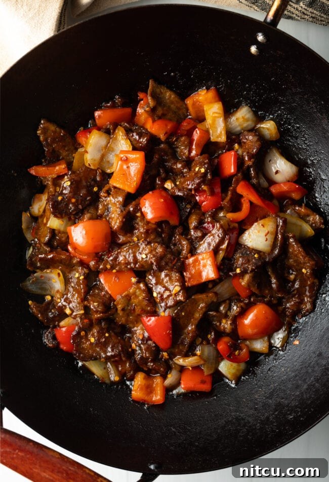 Top down view stir fry beef with veggies in a wok.