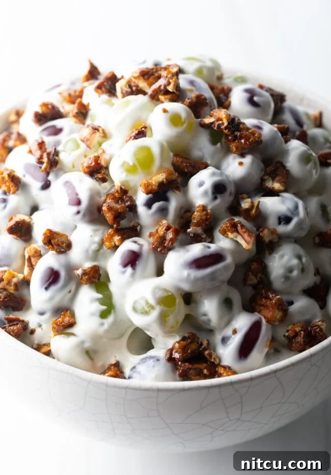 Close top down view salad made with green and red grapes, cream cheese, and pecans.