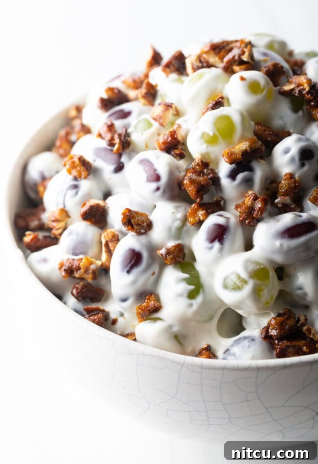 Close top down view salad made with green and red grapes, cream cheese, and pecans.