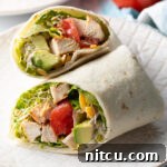 Top down view loaded chicken wrap, two pieces of the wrap are lying criss cross on each other.