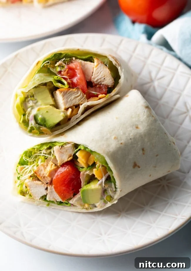 Top down view loaded chicken wrap, two pieces of the wrap are lying criss cross on each other.
