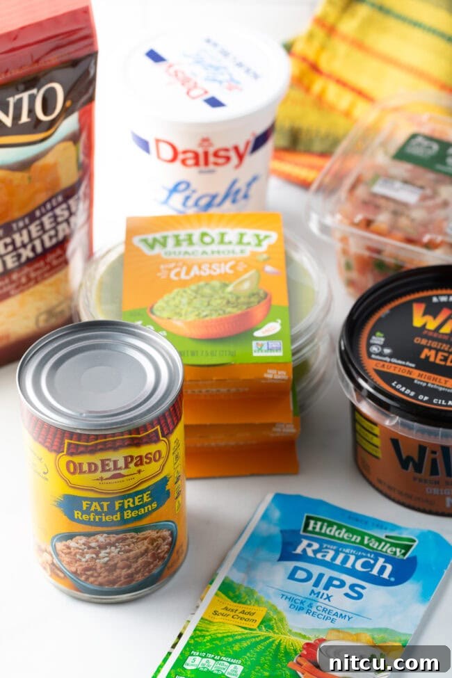 Recipe ingredients: can of beans, guacamole, shredded cheese, salsa, sour cream, ranch seasoning packet.