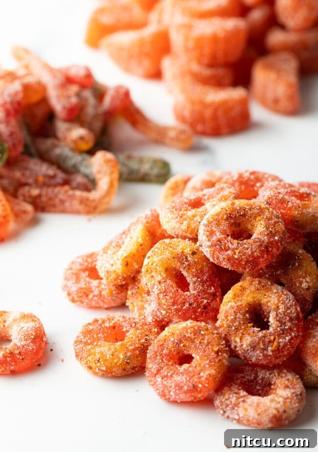 Close view of pile of Mexican chamoy candy gummy rings, glistening with sauce and spice.